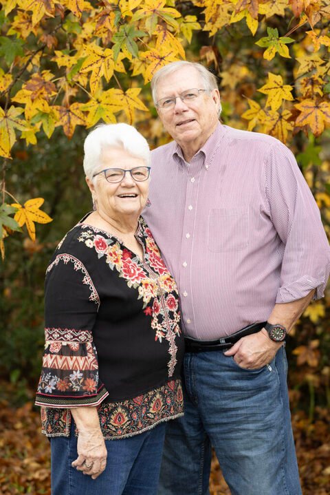 Couple in the fall colors during their session in the Tx state forest with Kara Powell Photography.