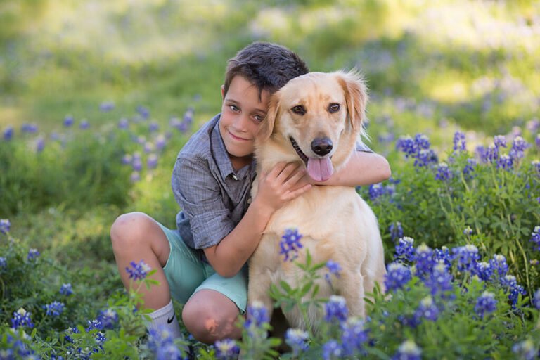 A boy and his golden retriever in the Texas blue bonnets. Taken by Kara Powell Photography.