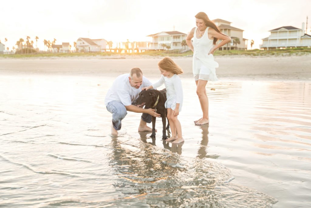 Parents with five year old and dog on beach in Galveston TX
