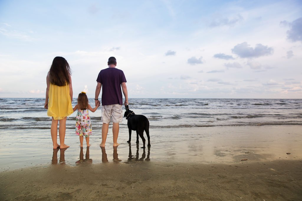 Parents with five year old and dog on beach in Galveston TX