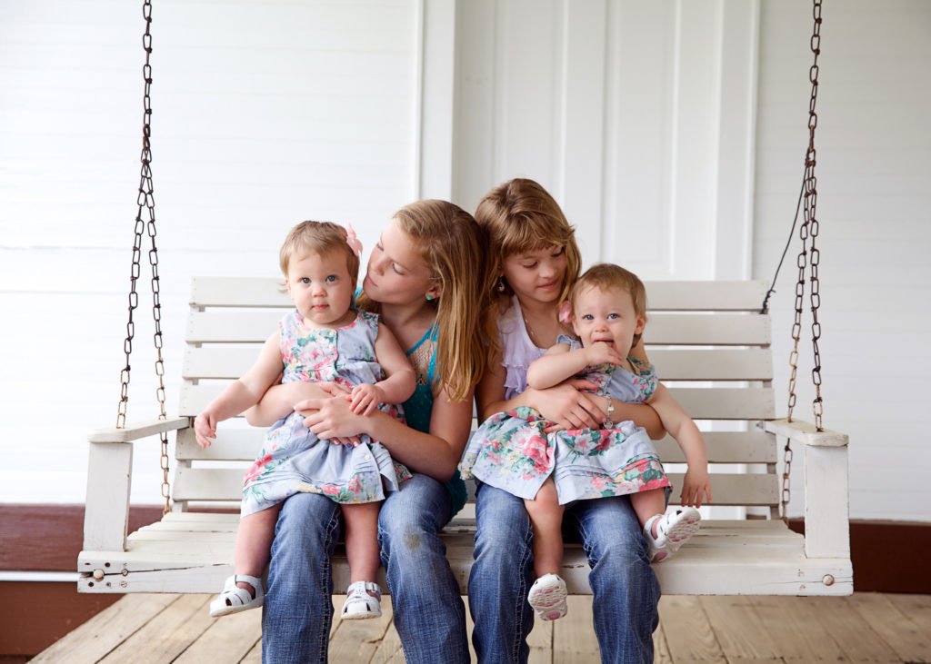 Double set of twins on porch swing in Montgomery TX