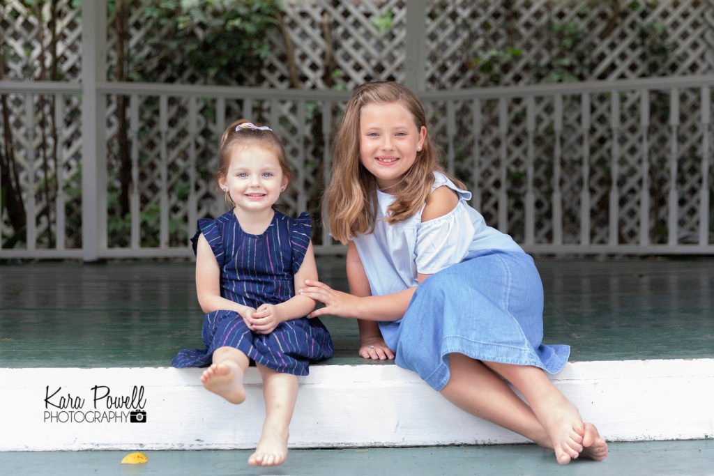 Sister siblings in a gazebo at secret garden mini sessions in Conroe TX