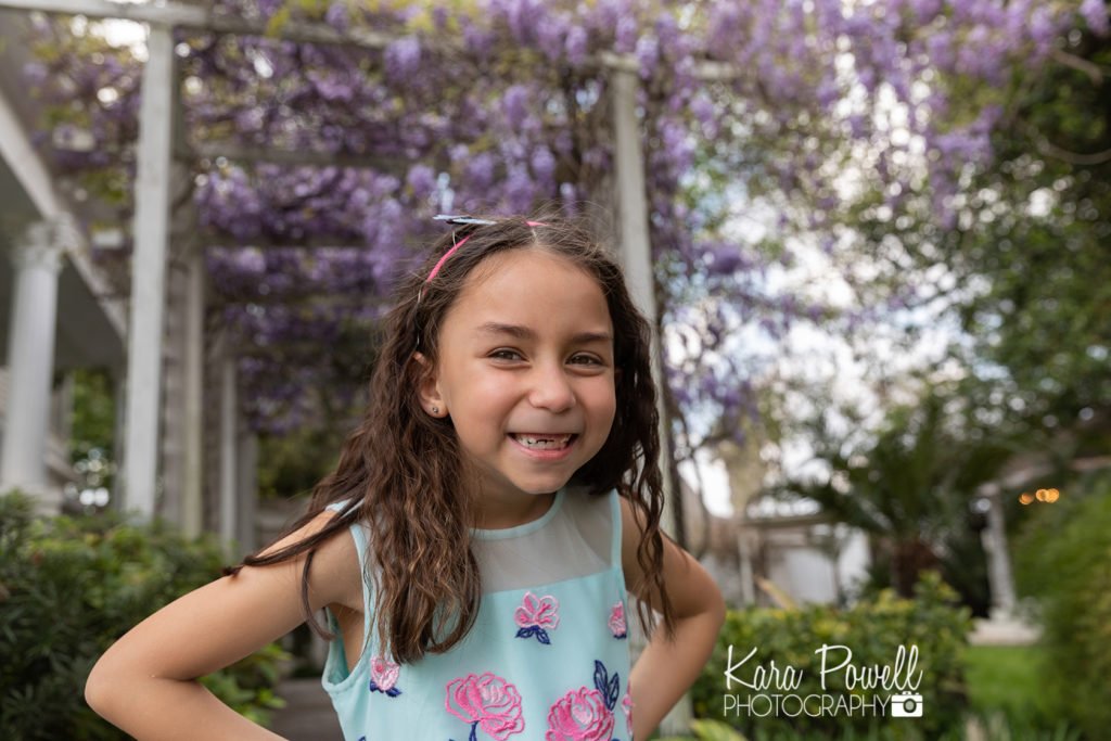 Six year old under wisteria during spring in Conroe TX
