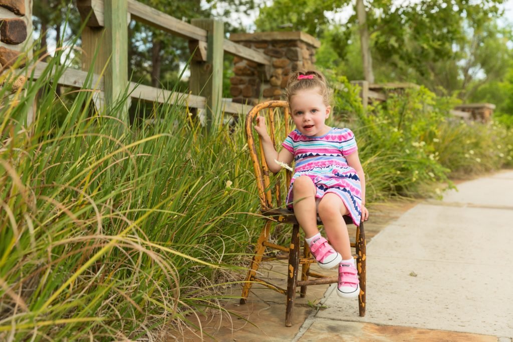 Two year old sitting on a chair in Woodlands TX park