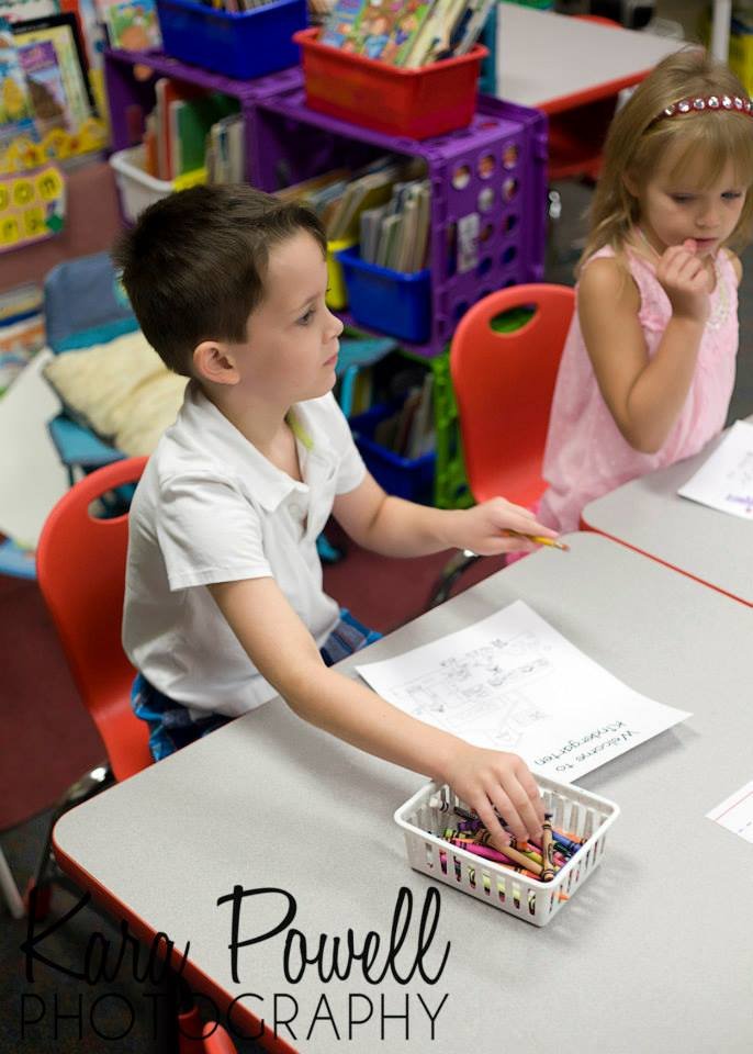 kindergartner at his desk with crayons