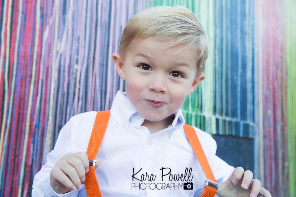 Houston Photographer - Little boy stand in front of colorfully painted wall