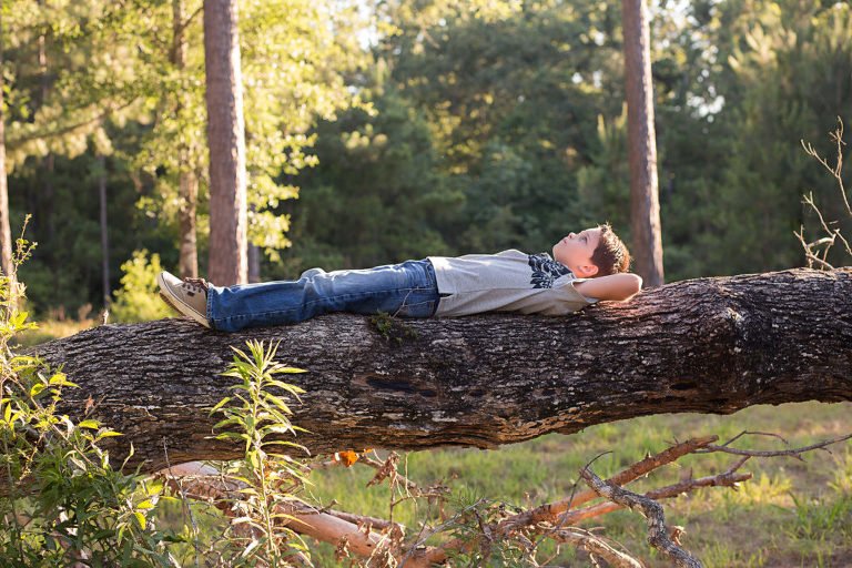 School photos alternatives - 4th grader laying on a fallen tree