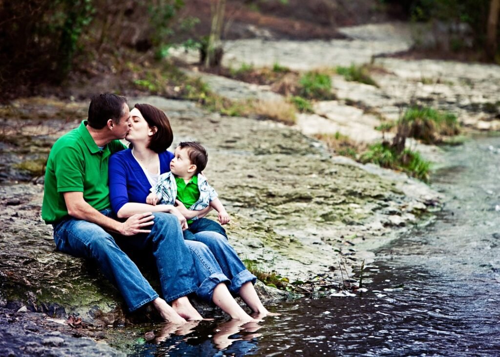 Family of three sitting at a creek bed with their feet in the water. Good images that stand the test of time.