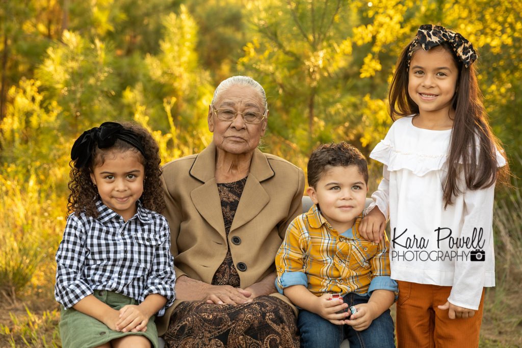 Woodlands generation photographer - Great grandma and her three great grand kids smile in the woods