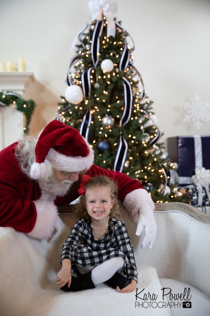 Woodlands TX two year old spends quiet time with Santa at Kara Powell Photography's studio