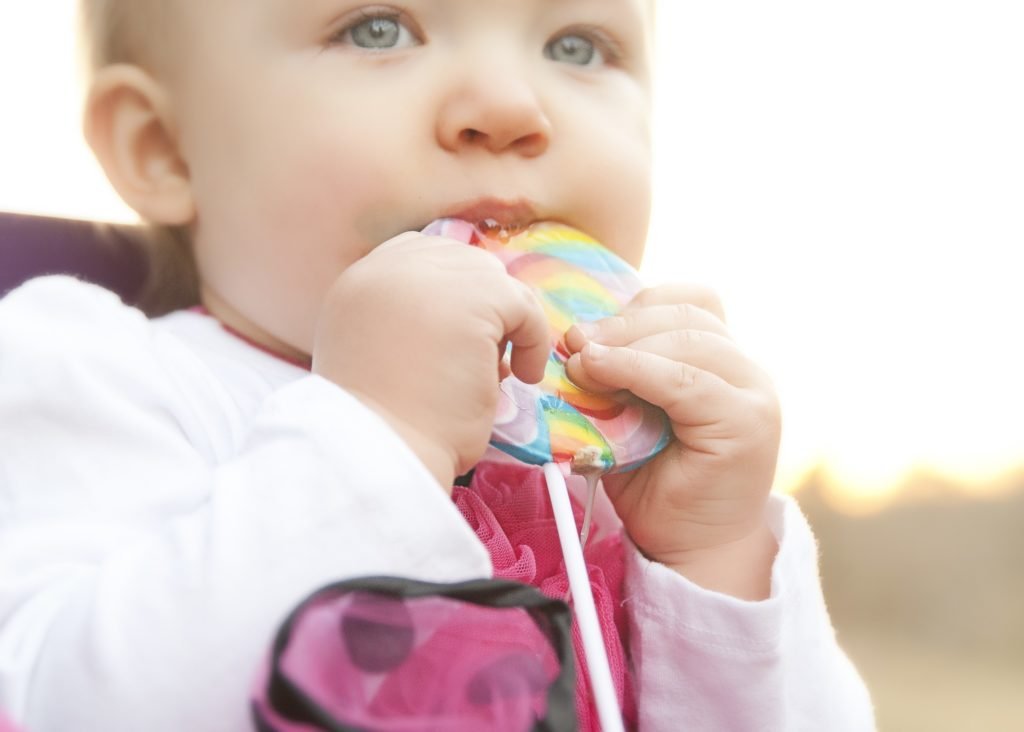 Little girl eating lollipop