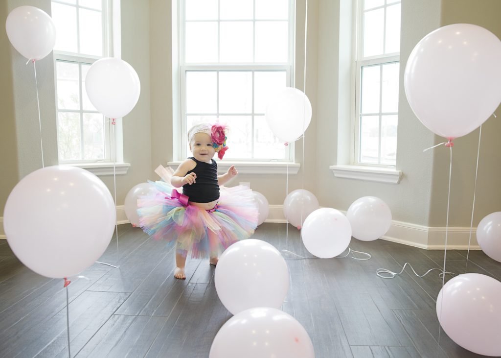 little girl in balloon filled room