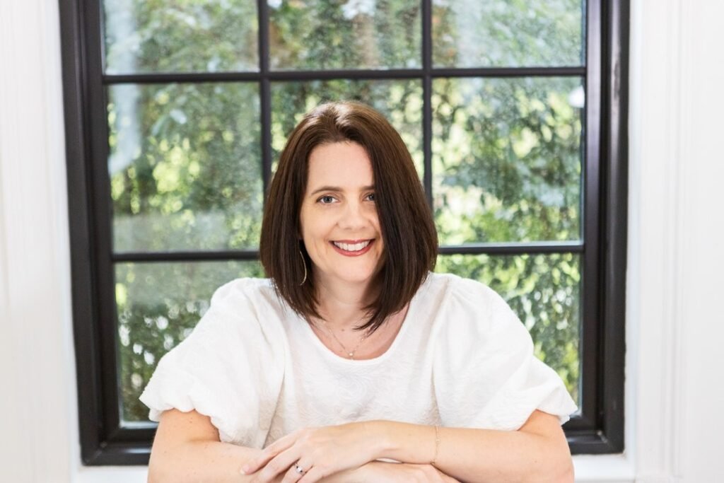 Photo of Kara Powell sitting in front of a window thinking about a photographers why