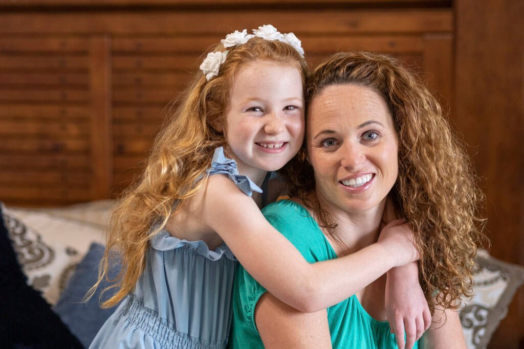 Red headed Mother and daughter posing together for a photo