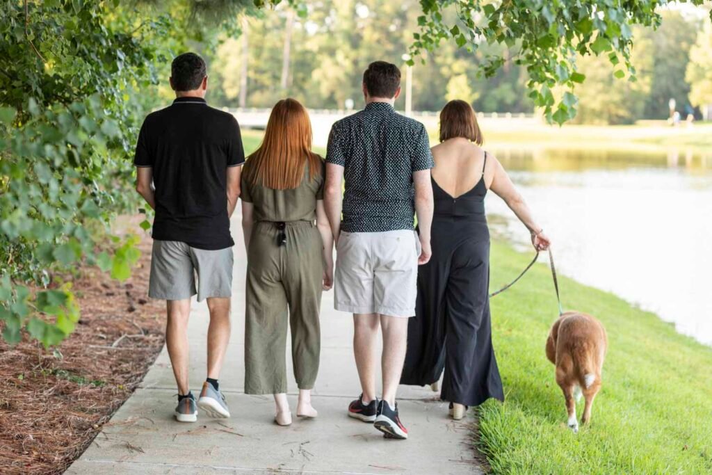 Family of four and their sweet 11 year old dog buddy walking away down the path