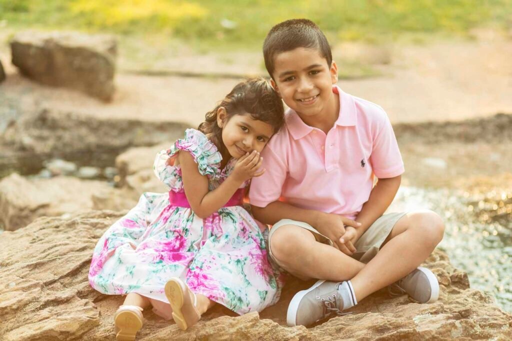 Two kids sitting by a river