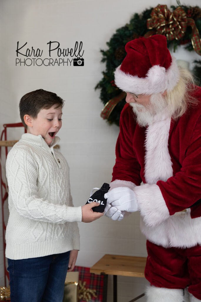 A little boy is shocked to receive a bag of coal from Santa Claus