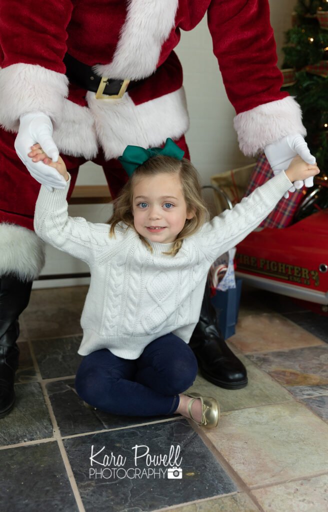 A little girl plays with Santa Claus during her Quiet Time with Santa Session