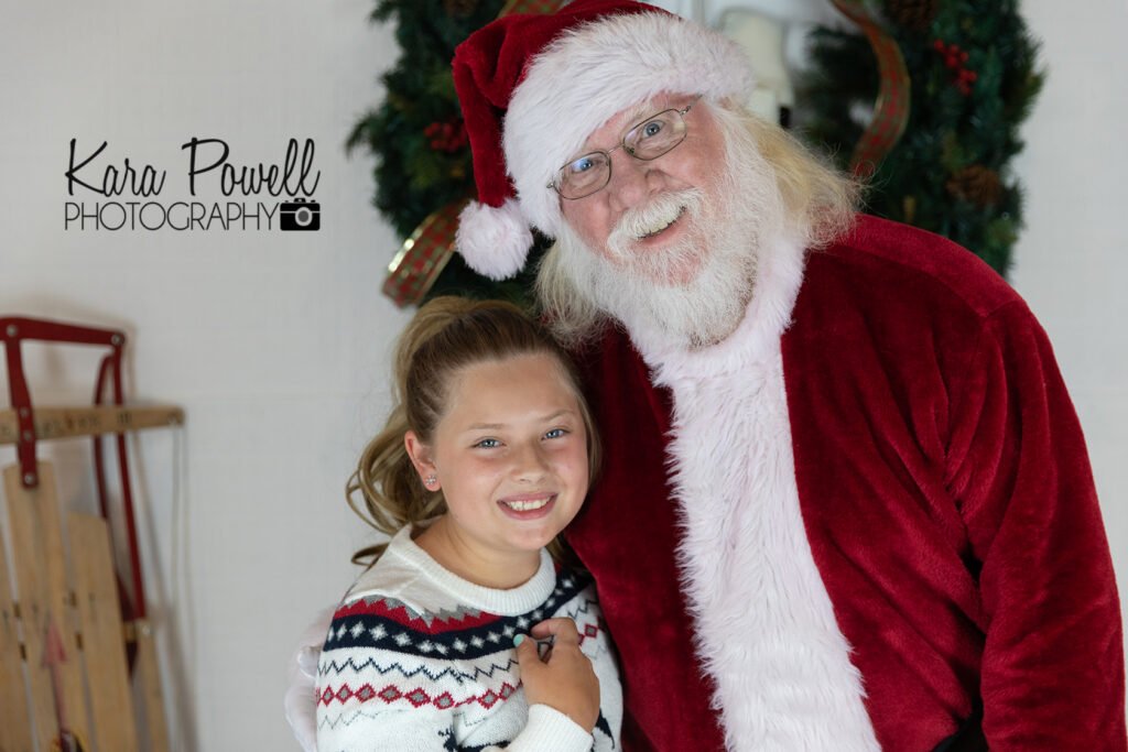 A little girl smiles with Santa