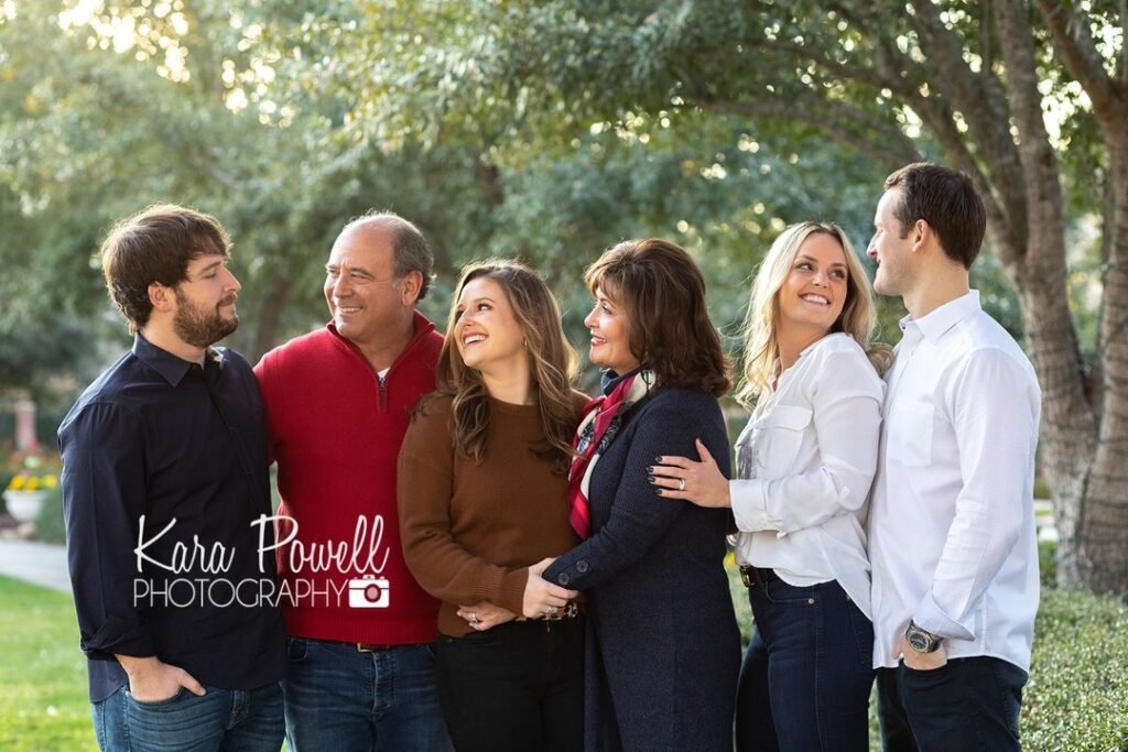 A family of 6 gathers together at a park for extended family sessions