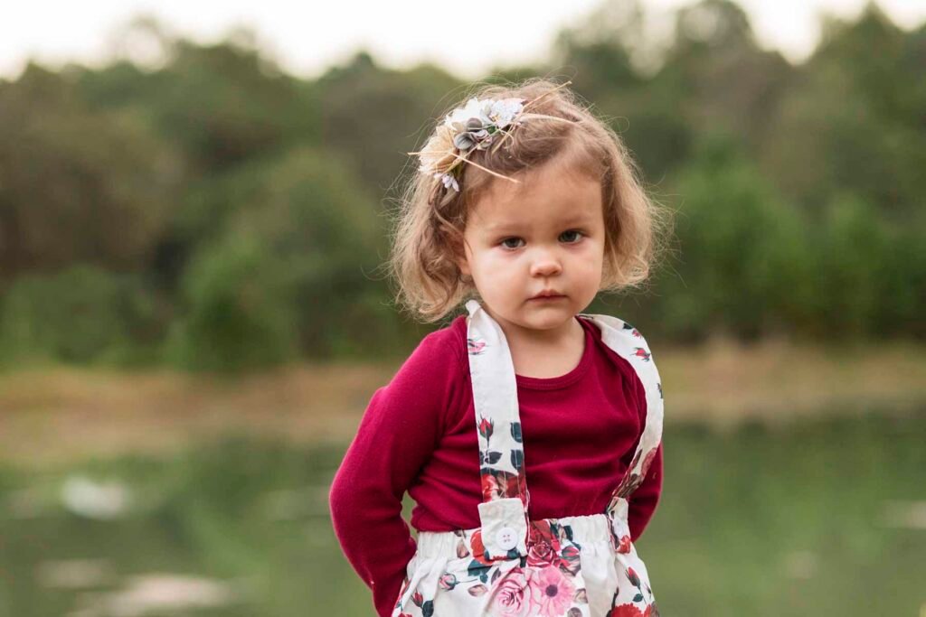 A little girl looks solemnly into the camera.