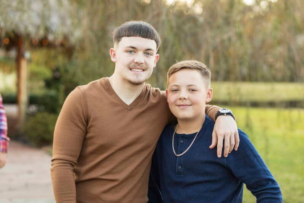 Two brothers pose with a green background at their Townhall TX fall family session