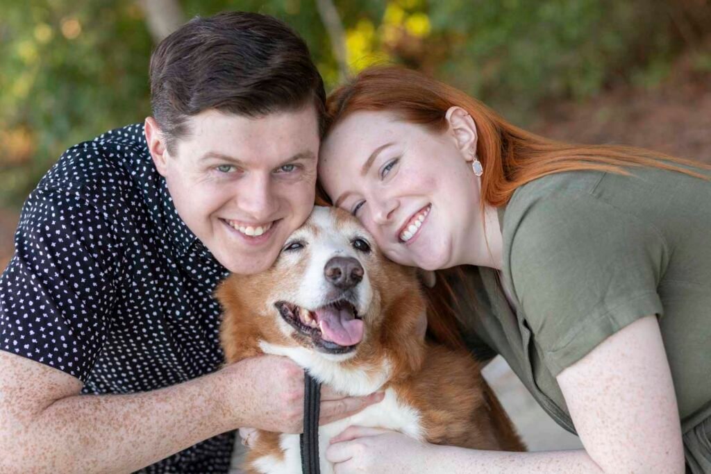Two teens hug their dog