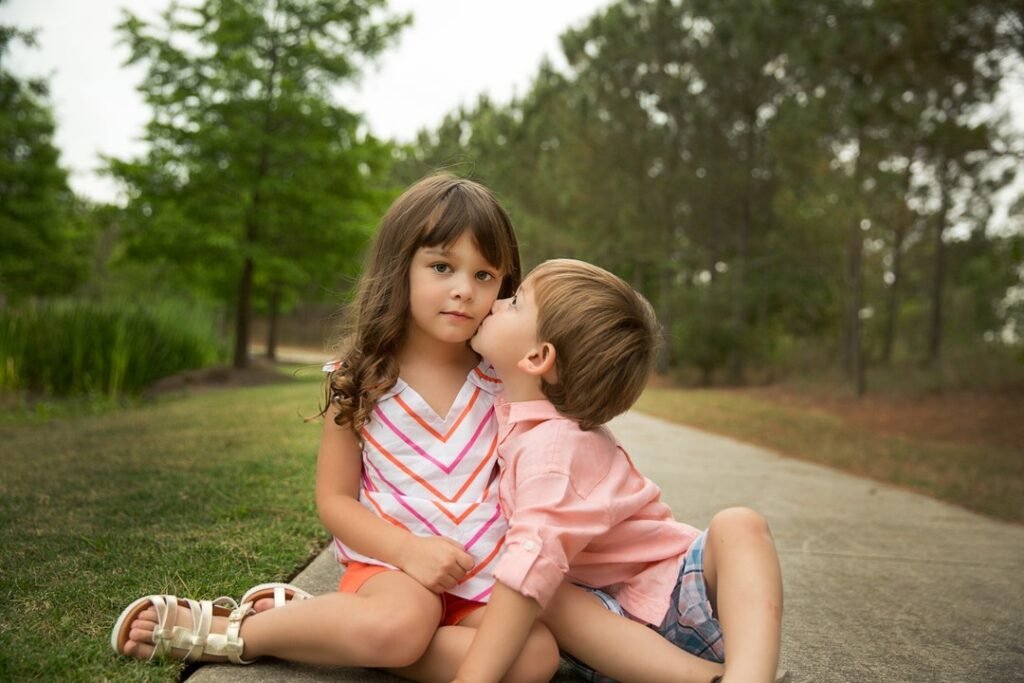 Cousins sitting on the sidewalk in the Woodlands TX