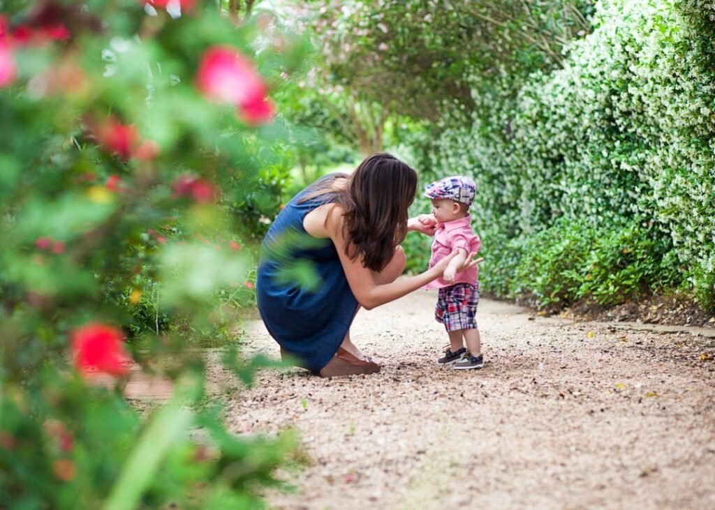 A behind the scenes photo of a mother and her son on a flower lined path