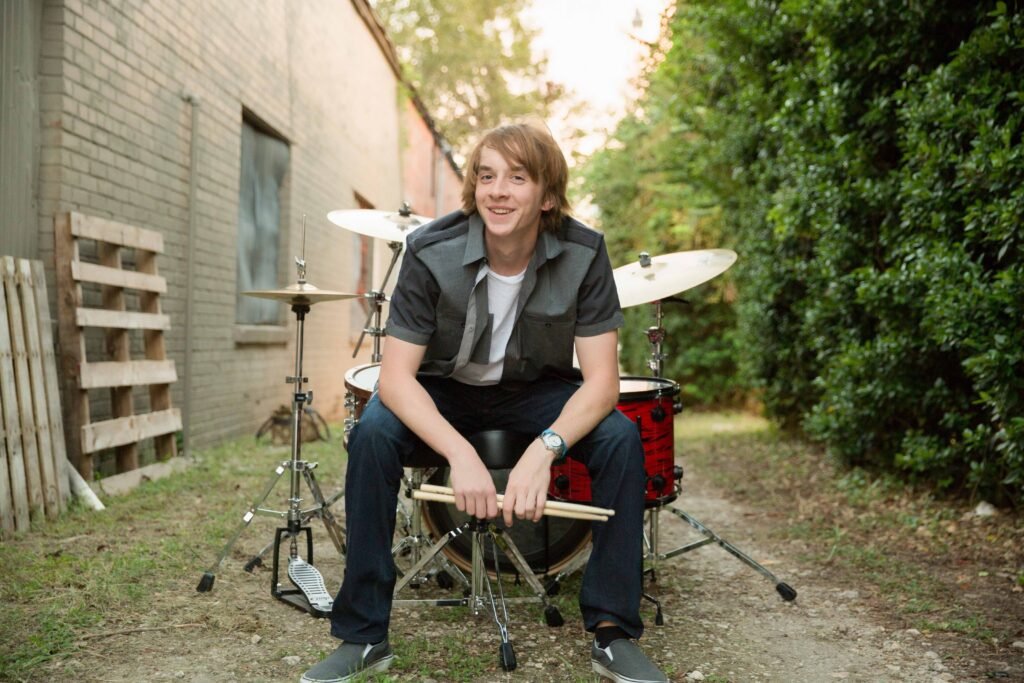 2019 Senior boy in downtown Conroe TX by abandoned building with his drum set