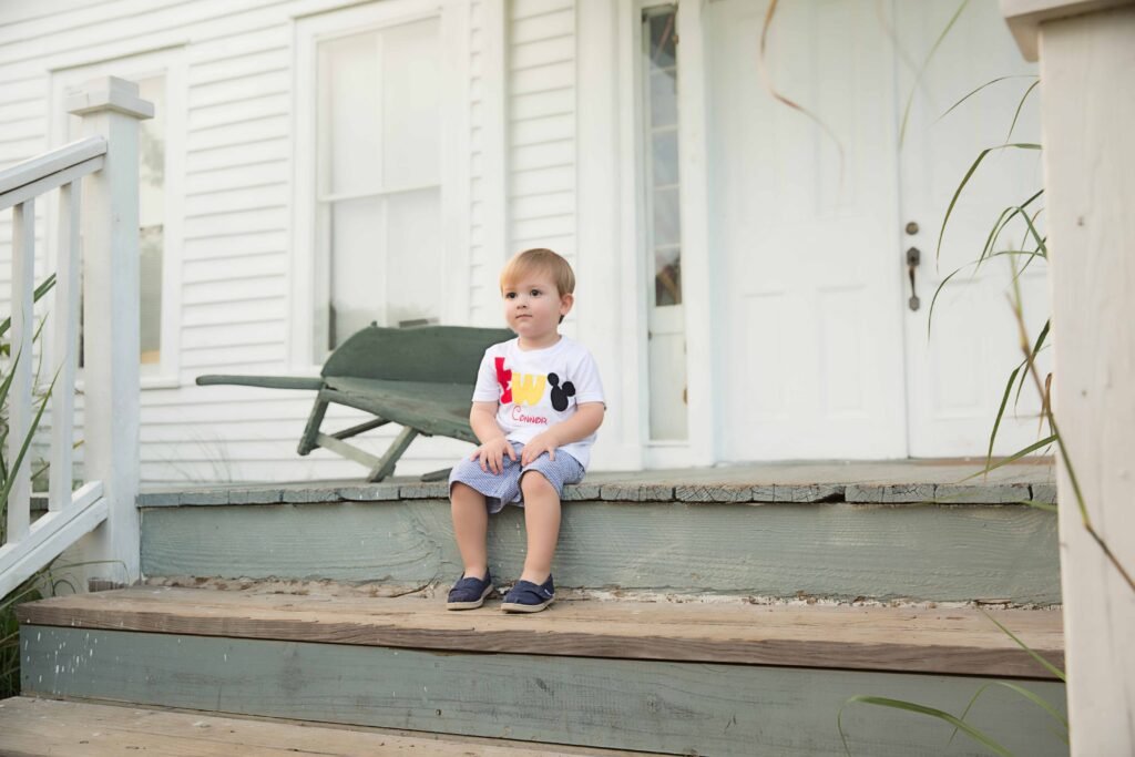 Two year old sitting on the steps of an old school house in Montgomery TX
