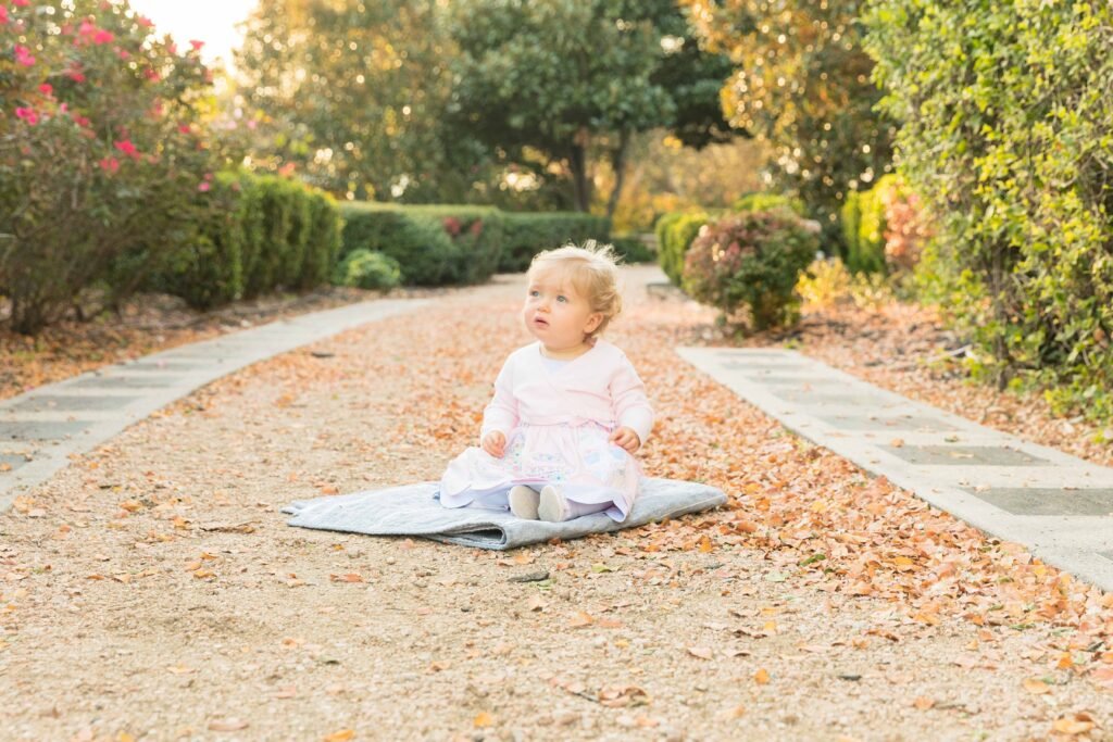 One year old sitting in rose garden in downtown Houston TX