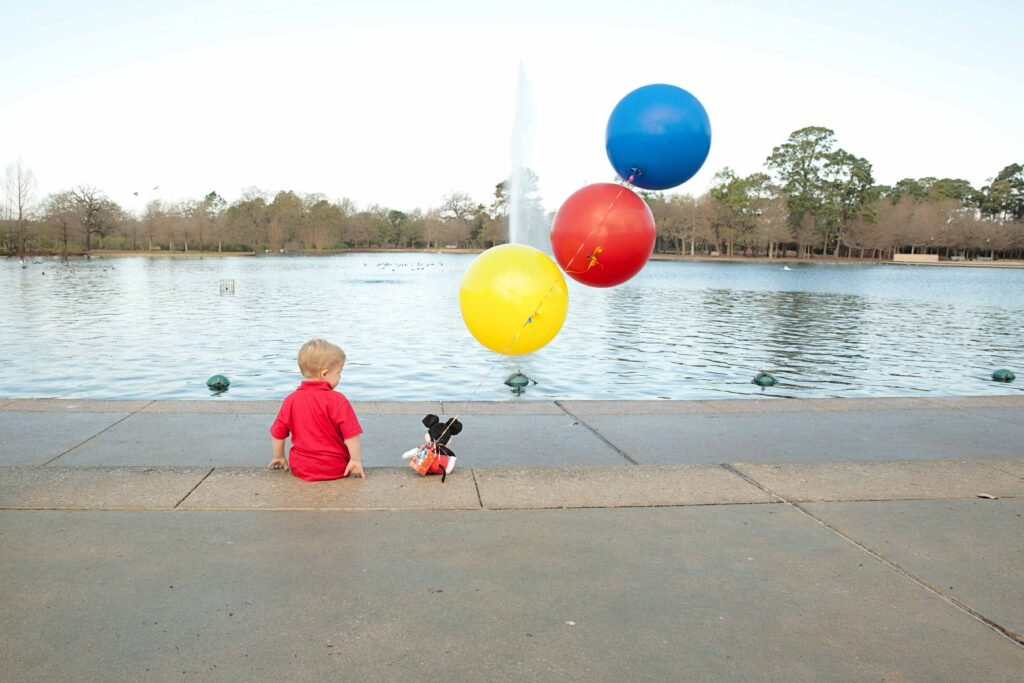 Three year old with balloons outside of the Houston TX zoo
