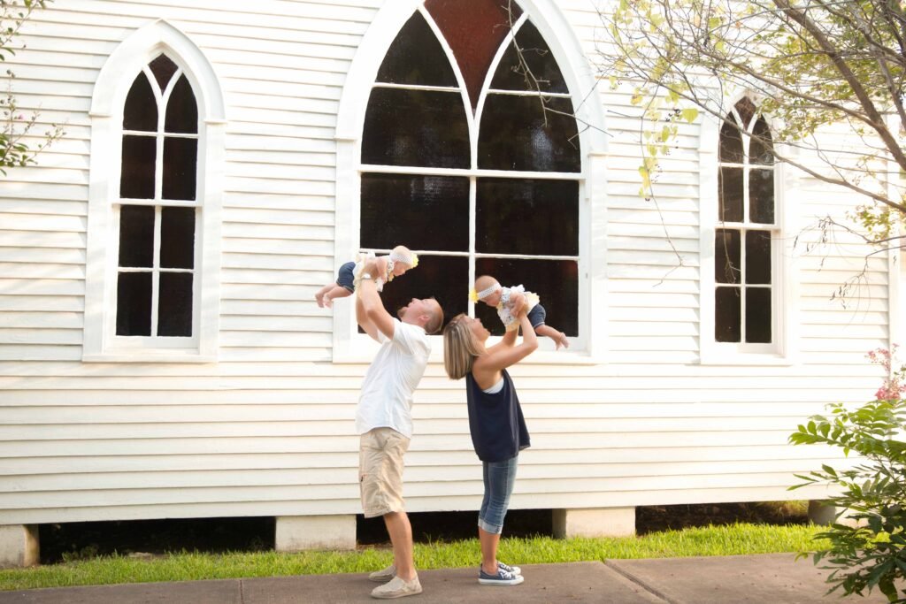 Parents with twin girls in front of historic church in Montgomery TX