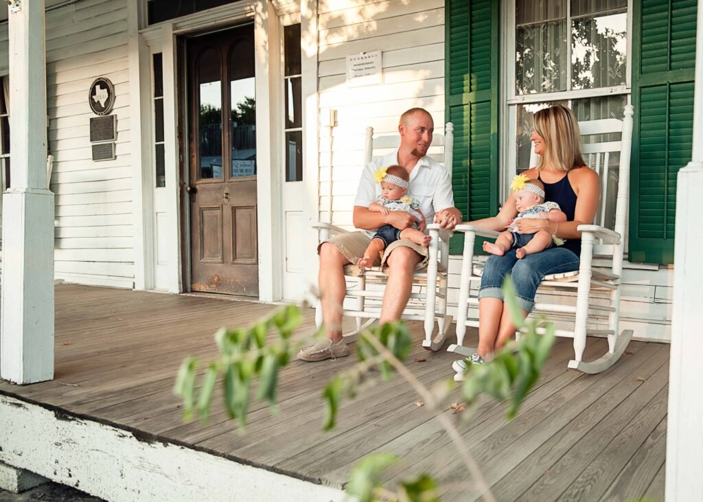 Parents with twin girls in front of historic home in Montgomery TX