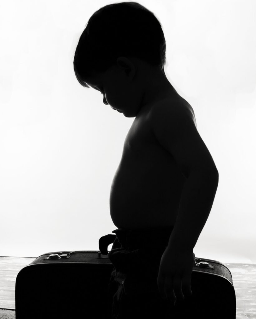 Silhouette of little boy and suitcase in Houston TX