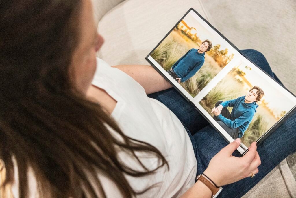 Client looking at their album designed by Kara Powell Photography