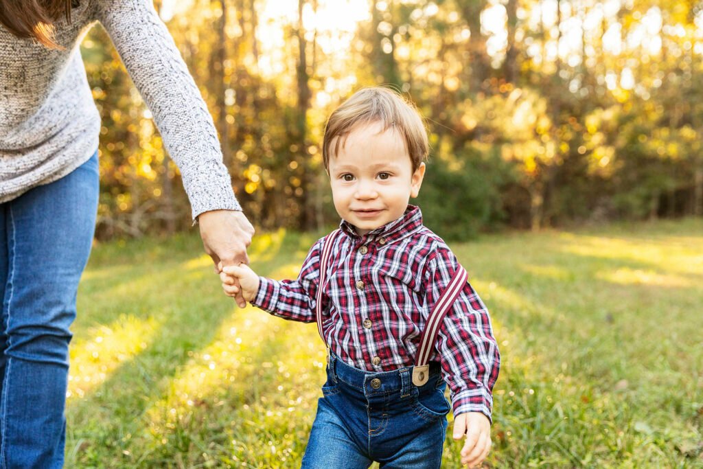Little boy holding his mom's hand at sunset in Alden Bridge park, Kara Powell Photography
